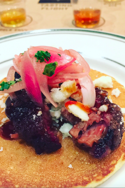 BBQ brisket and pickled red onion on a corn cake